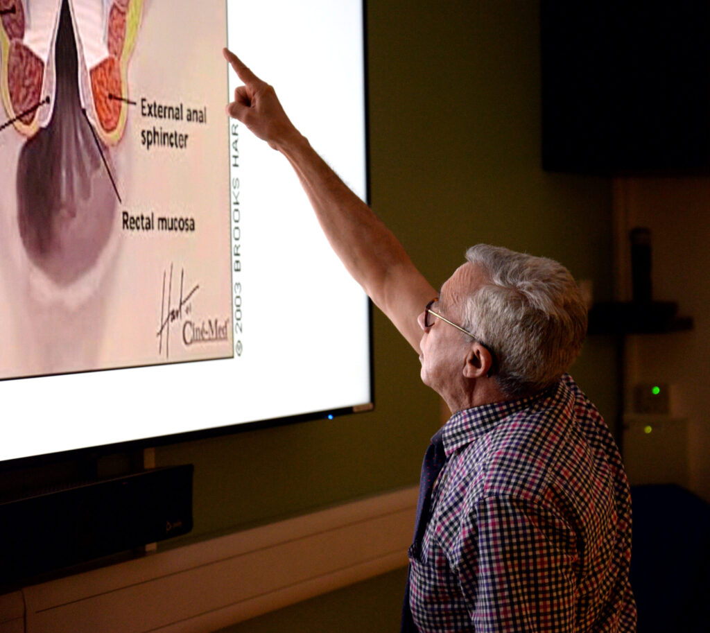 A faculty member pointing to an anatomy slide of the anal sphincter