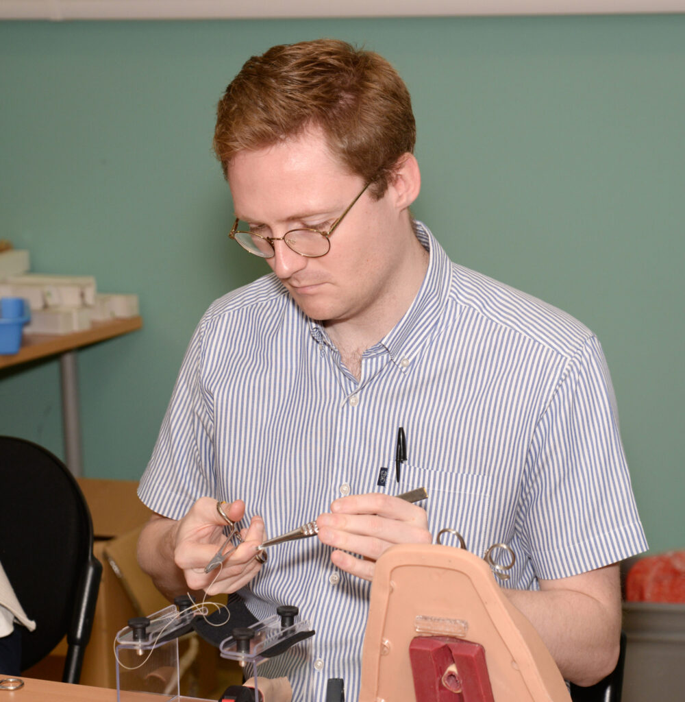 A delegate suturing on a perineal trainer model