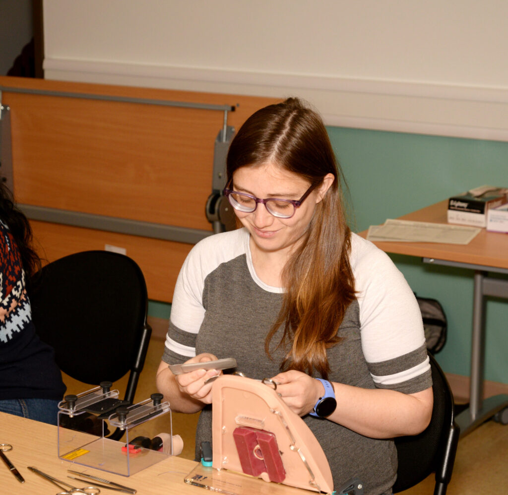 A delegate concentrating on a repair at a perineal trainer