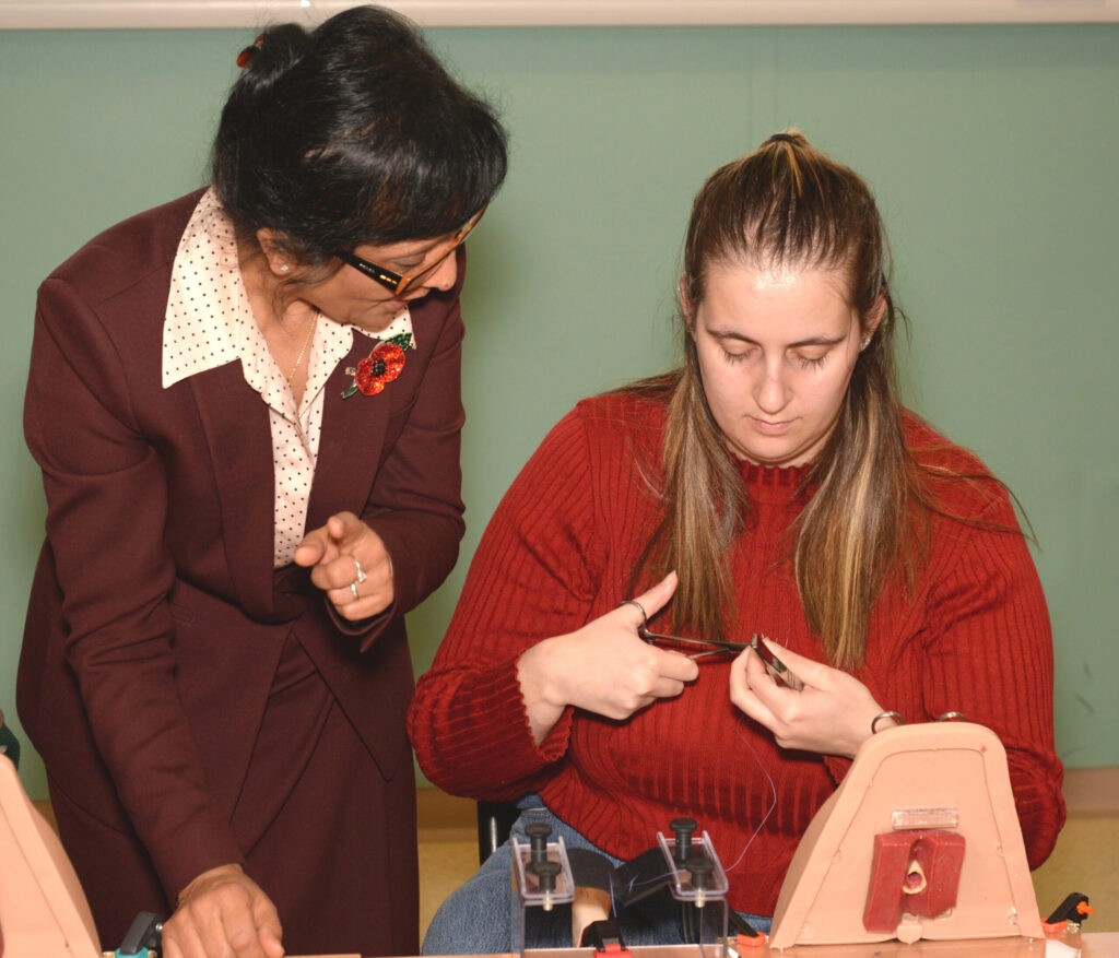 A faculty member advising a delegate during the practical workshop