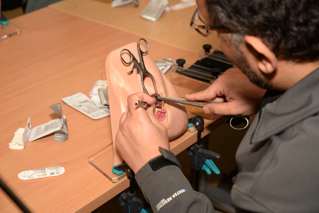 Close-up of a delegate suturing a perineal trainer