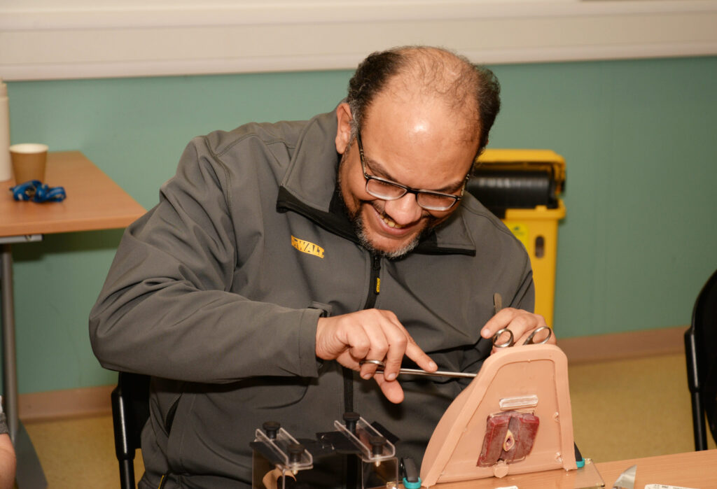 A delegate carrying out a repair on a perineal trainer